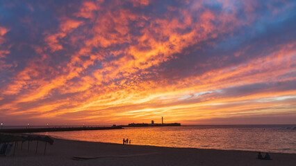 Fototapeta premium Very colorful sunset with the casle of San Sebastian at the horizon in Cadiz, Andalusia, Spain
