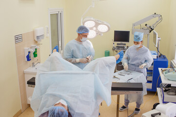 the proctologist together with the assistant to prepare for the operation.