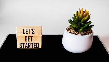 LET'S GET STARTED text on wood block with cactus flower, white and black background