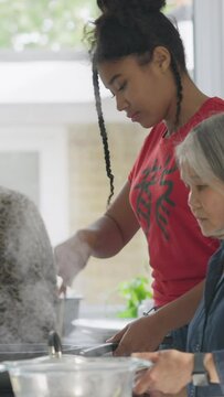 Senior women and teenage girl cooking together