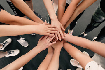 Teamwork of group of children. Hands of people putting hands on hands showing expression agreement and friendship before competition