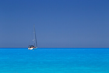 Fototapeta premium White yacht anchored in fantastic Myrtos Beach turquoise and blue bay. Summer scenery of famous and extremely popular travel destination in Cephalonia island, Greece, Europe.