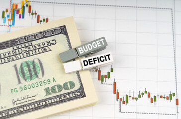 On the charts of quotations are dollars, clothespins with the inscription - budget deficit
