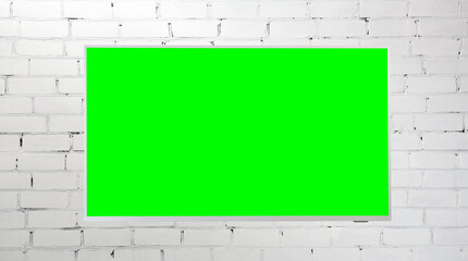 Green screen LED TV on a brick white wall indoors. Living room. The concept of a country house.