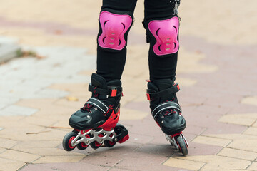 Legs of a child rollerblading in the park