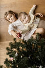 children lying by the Christmas tree top view