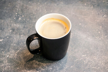 Americano coffee served in a cup isolated on dark grey background top view of hot coffee