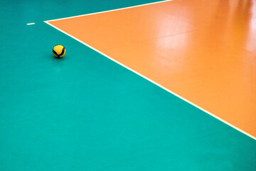Volleyball court with ball in sports hall, top view, copy space. Background sports image of volleyball ball on court in gym. Concept of team game, active match, healthy lifestyle and team success