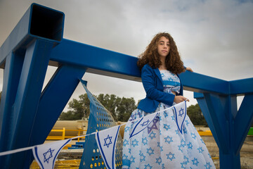 Beautiful jewish dark hair girl or woman with Israel jewish symbols dressed in the colors of the...
