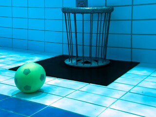 Unterwasserrugby Tor und Unterwasserrugby Ball auf dem Beckenboden eines Schwimmbeckens.
