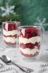 New Year layered dessert Trifle Red velvet with biscuit and cream cheese on green background, Vertical image