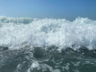 Naklejka premium Beautiful sea with waves splashing warm sparkling clear blue water in a warm tropical oriental country southern resort. Background, texture