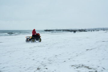 Fototapeta na wymiar a lifeguard riding a quad in winter