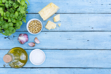 ingredients for making pesto sauce on a blue wooden background. basil, pine nuts, garlic, parmesan. space for text, copy space