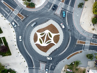 Aerial drone view of roundabout in the city. Cars moving fast. Traffic on roundabout in town, view from above. Transportation.   - obrazy, fototapety, plakaty