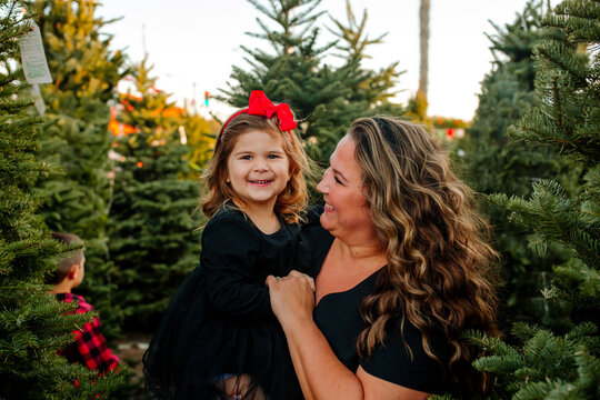 Happy Mother and daughter in front of pine trees 