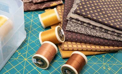 Sewing thread, colored fabric with various patterns and colors for sewing, quilting and crafts.