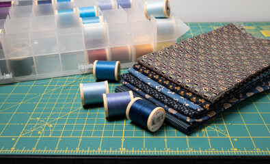 Sewing thread, colored fabric with various patterns and colors for sewing, quilting and crafts.