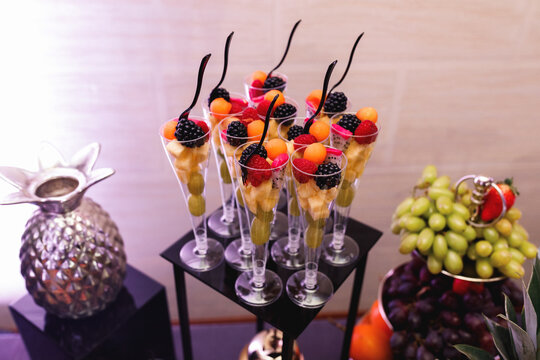 Fruits in glasses on sideboard 
