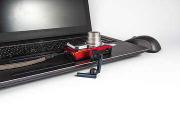 Laptop with wireless mouse, red digital camera, black wireless headphones and memory SD card - EDC everyday carry - empty space - white background