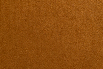 Texture of brown suede or velour cloth close-up. Natural or artificial sewing material. Fabric as background for design