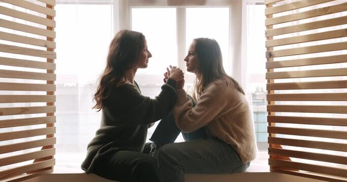 Couple of women hug each other warmly and relax at home in the bedroom. Close up look at face. look in the eyes in love. lgbt and lesbian women at home. Romance and portrait of lesbian couple enjoying