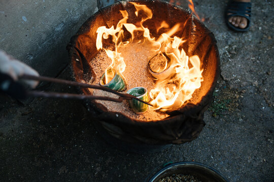Crop potter firing cups in kiln