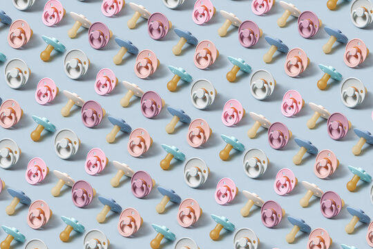 Pattern of colorful pacifiers on blue background.
