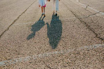 Mother and daughter shadow on asphalt