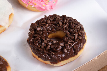 Sweet donuts covered with cream and milk powder and other donuts covered with chocolate