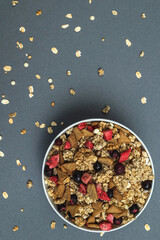 Obraz na płótnie Canvas A bowl of muesli on a gray monochrome background, healthy food, healthy breakfast