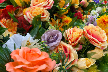 Many multicolored artificial flowers on the counter in the store