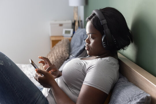 social media, woman in headphones listening music on smartphone