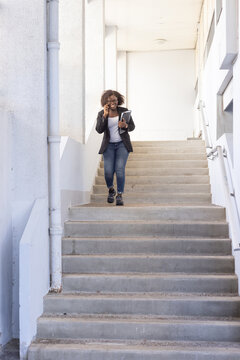 business woman walking on stairs, talking on the phone, smiling