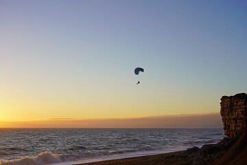 Para-glider over the beach at the sunset