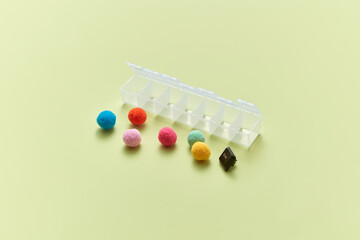 Colorful spheres beside medicine organizer.