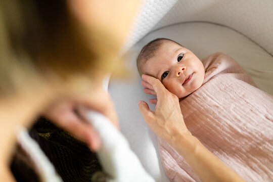 Woman Strokes The Cheek Of Newborn Baby