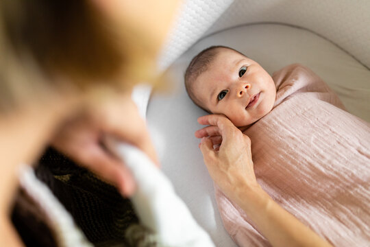 Mother Touches The Cheek Of Newborn Baby