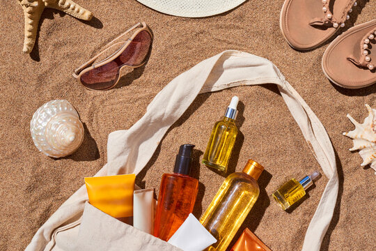 Set of cosmetic products in bag on sand beach in summer