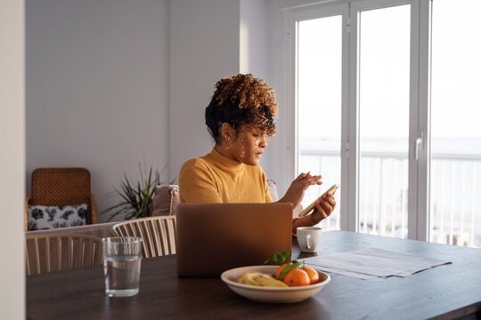 Female freelancer using smartphone during work