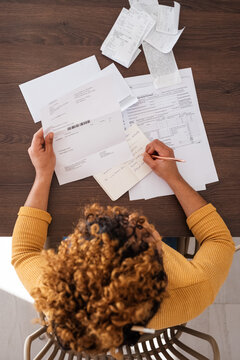 Female accountant writing down data from paper