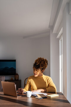 Freelancer checking data in planner and on laptop