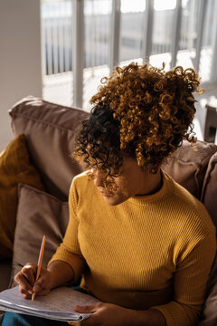 Hispanic woman writing down data in planner