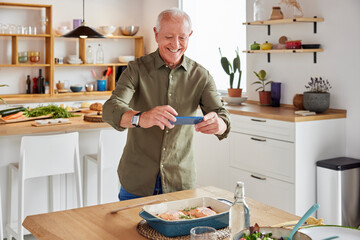 Cheerful senior man taking photo of baked food