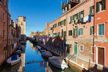 Fototapeta na wymiar Traditional Venetian houses along the canal on a sunny day.