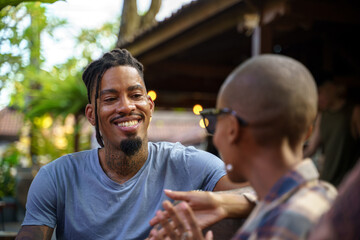 Young man happily listening to friend speak