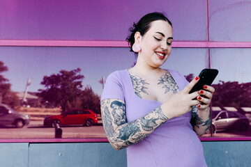 Stylish brunette using mobile phone on street