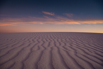 Fototapeta na wymiar Ripples of Purple Dunes Disappear Into The Horizon At Sunset