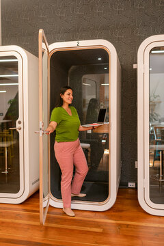 Woman getting out of phone cabin