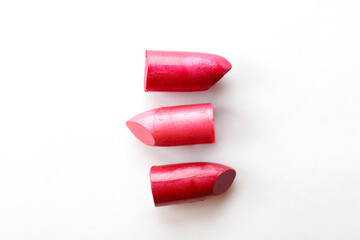 Close up shot of three glossy lipstick heads without a tube, isolated on white background with a lot of copy space for text.